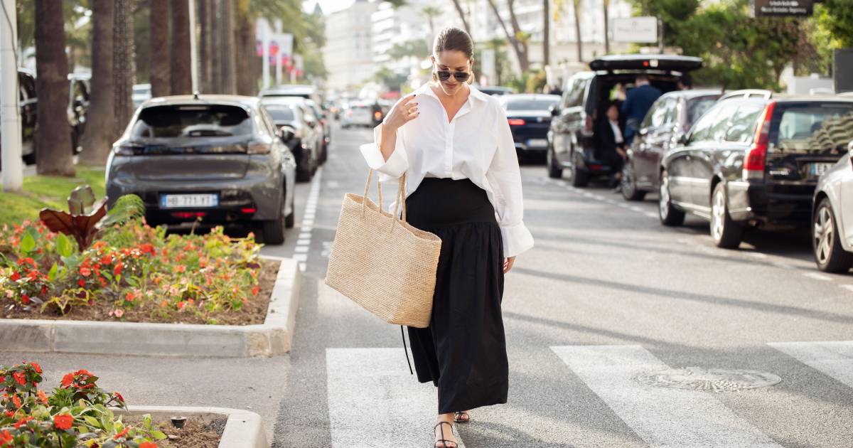 Cannes, France - May 15: Gili Biegun wears a long black maxi skirt, a white long sleeve shirt, an overly large beige straw bag, sunglasses and golden earrings of the sea shell during day three of the 78th Cannes Film Festival on May 15, 2025 in Cannes, France. (Photo by Raimonda Kulikauskiene/Getty Images)