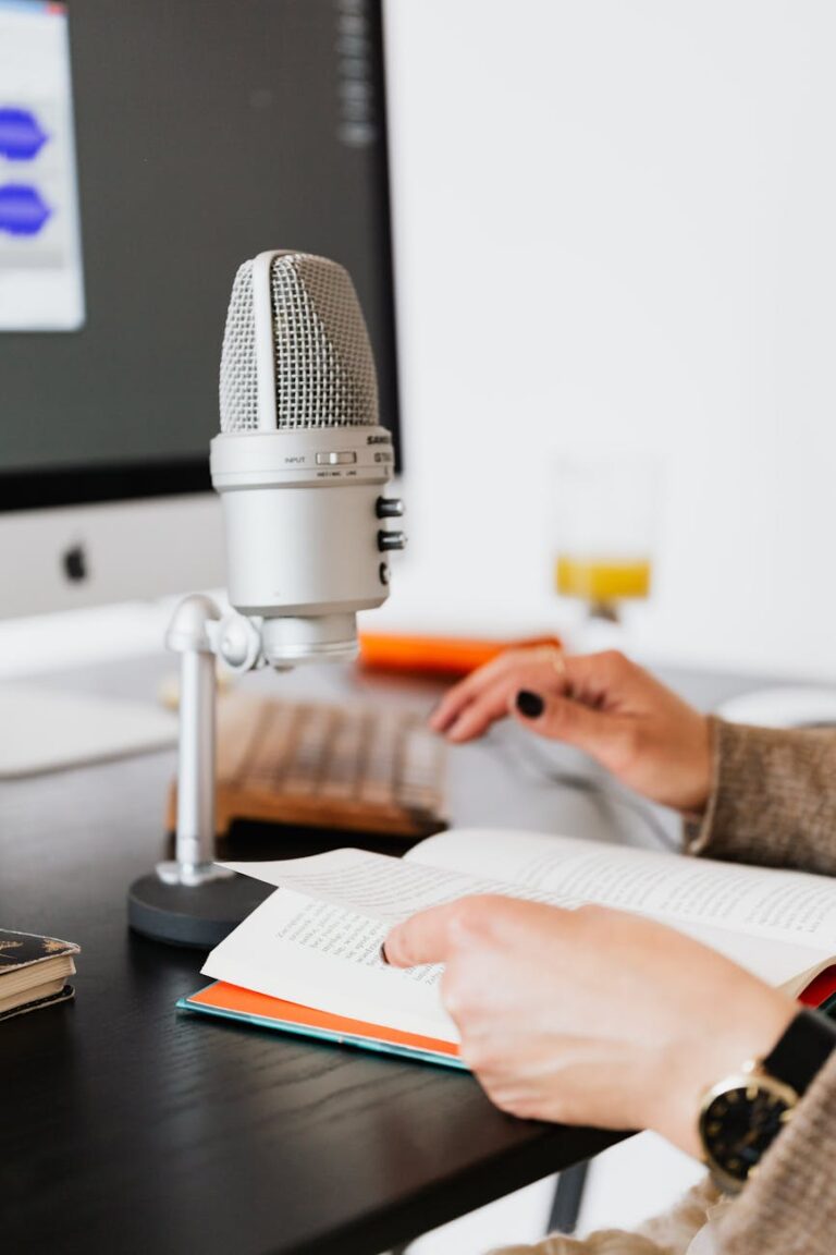 Hands holding a book near a microphone, perfect for recording or podcast scenes.